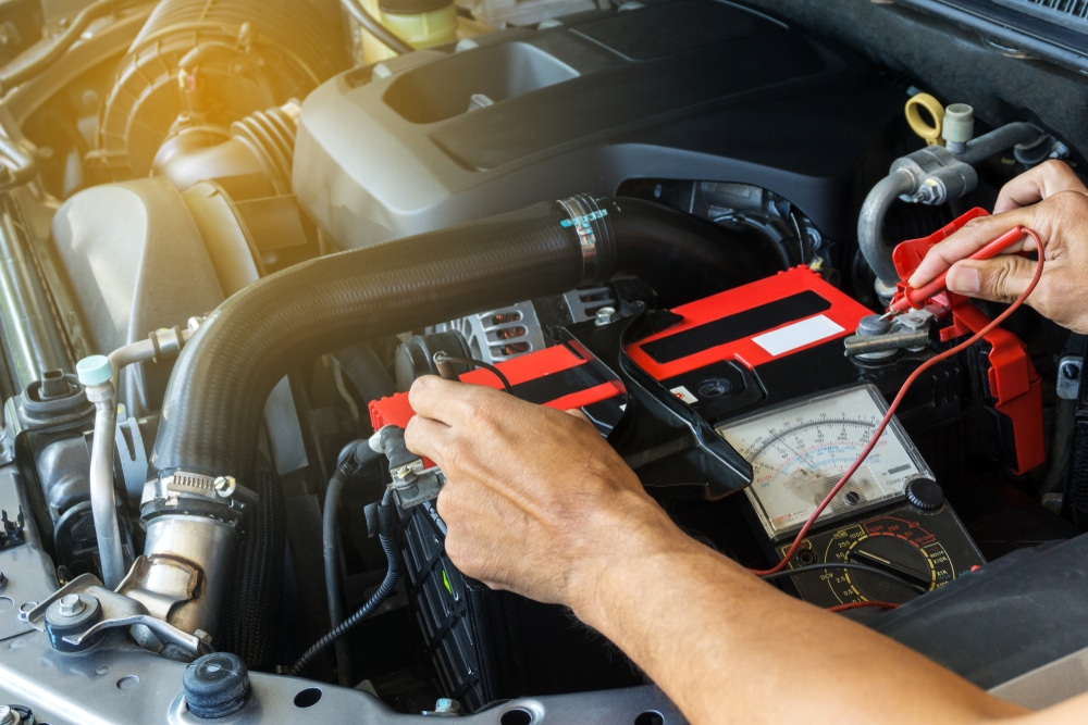 European Car Winter Battery Care - Rock Solid Auto Care, Mooresville. Image of mechanic using multimeter battery checker on car in sho