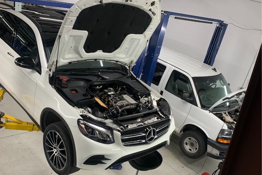 Maintenance Service Near me in Mooresville, NC with Rock Solid AutoCare. Image of a white mercedez benz being lifted for spring maintenance services in mooresville NC