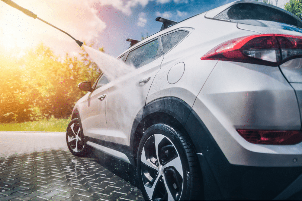 summer car tips, European auto repair in Mooresville, NC at Rock Solid Autocare. A silver SUV being pressure-washed under bright sunlight, emphasizing the importance of exterior vehicle care during summer months.